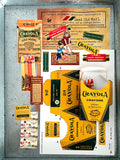 A vintage-style collage of Crayola items arranged on a gray textured surface, including multiple yellow and orange Crayola crayon packages, a large yellow '24 Crayola' card, a red 'Crayola Gold Medal' label, and a small illustrated card with a child and crayons. Good Old Mail snail mail club subscription for vintage items from goodoldmail.com
